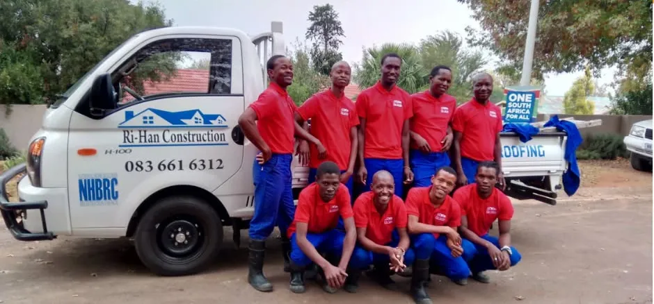 The Ri-Han Construction team in red uniforms beside the company bakkie