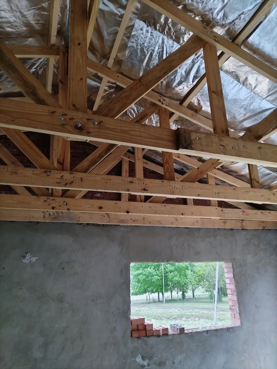 Timber roof trusses with insulation going on