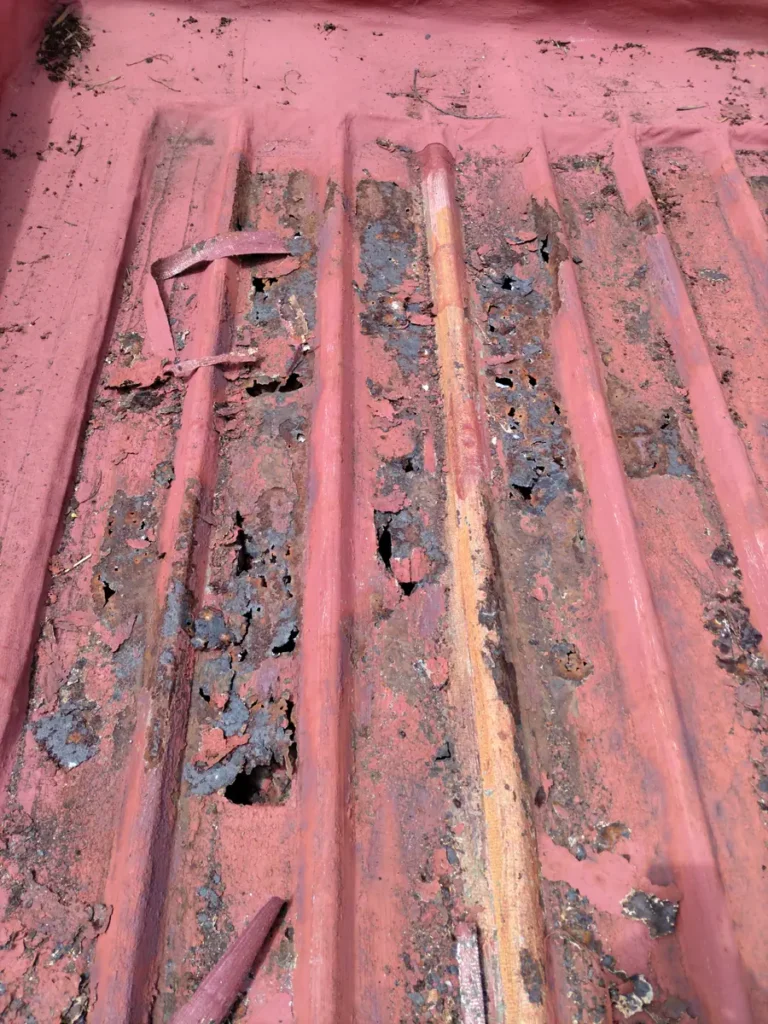 Rusted, damaged roof sheets before the repair