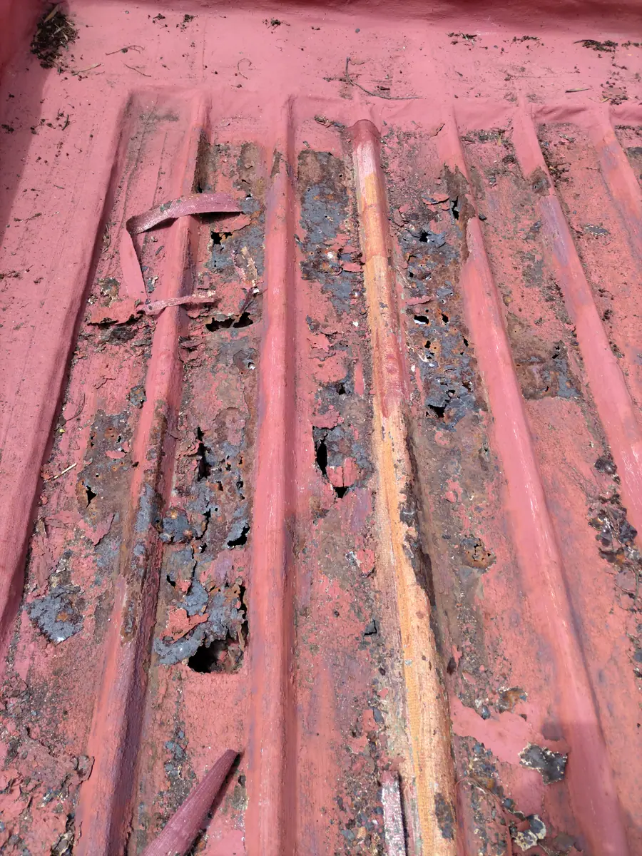 Rusted, damaged roof sheets before the repair